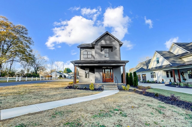 view of front of property featuring covered porch and fence