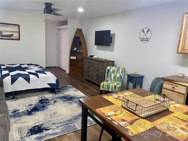 bedroom with ceiling fan, dark wood-type flooring, and a closet