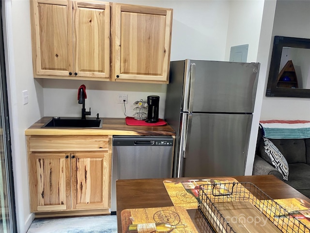 kitchen with light brown cabinetry, sink, and stainless steel appliances