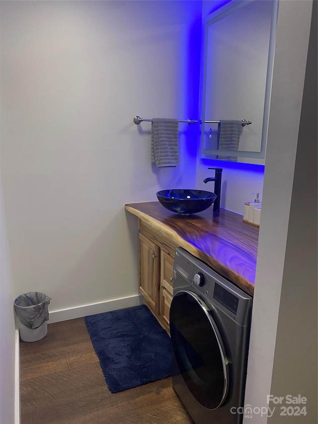 laundry room featuring sink, dark hardwood / wood-style floors, and washer / dryer