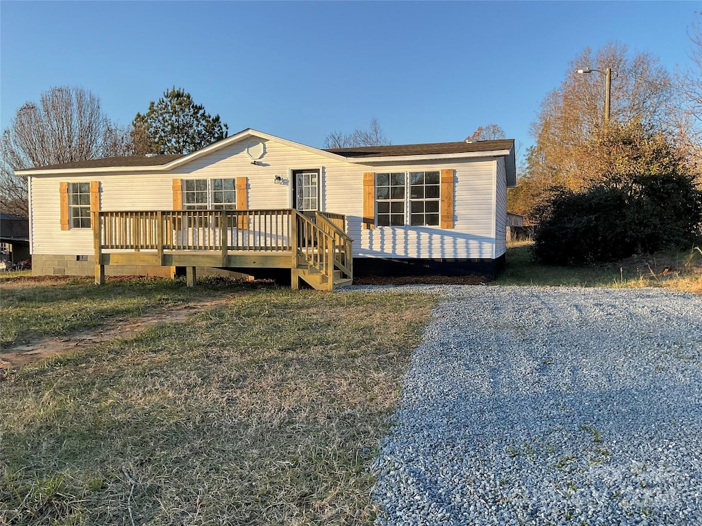 manufactured / mobile home with a front lawn and a deck