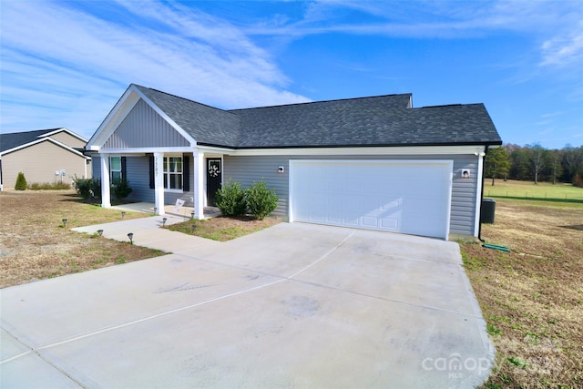 ranch-style house featuring a porch, a garage, and a front yard