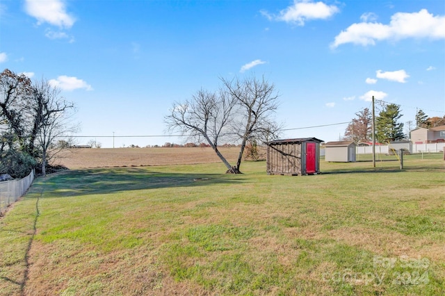 view of yard with a rural view and a storage unit