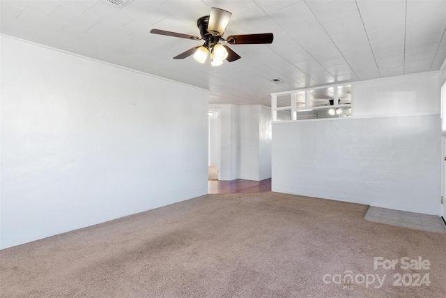 carpeted empty room featuring ceiling fan and crown molding