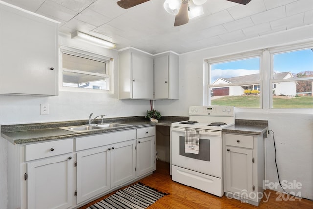 kitchen with white electric range oven, ceiling fan, sink, white cabinets, and light hardwood / wood-style floors