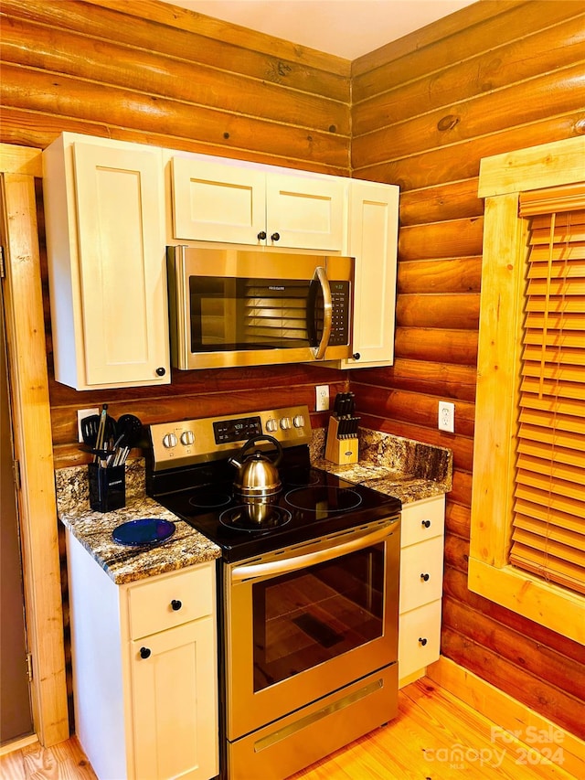 229 Seton Rd, Lake Lure, NC 28746 - kitchen with appliances with stainless steel finishes, log walls, white cabinets, light wood-style flooring, and dark stone countertops