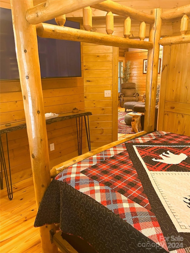 bedroom featuring hardwood / wood-style floors, rustic walls, and wooden walls