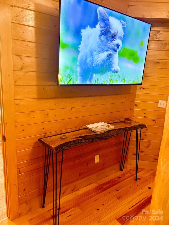 interior details with hardwood / wood-style floors and wood walls