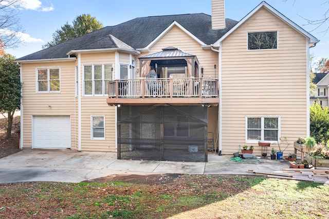 rear view of house featuring a garage, a gazebo, and a balcony