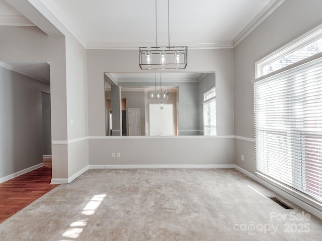 carpeted spare room featuring crown molding and a notable chandelier