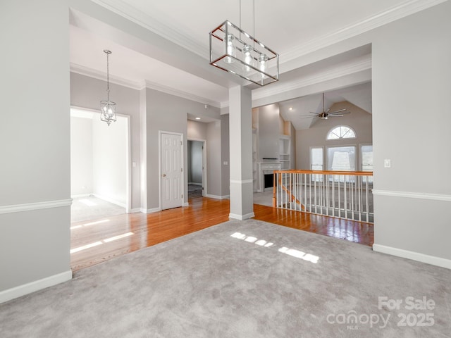 carpeted empty room featuring ceiling fan, high vaulted ceiling, and crown molding