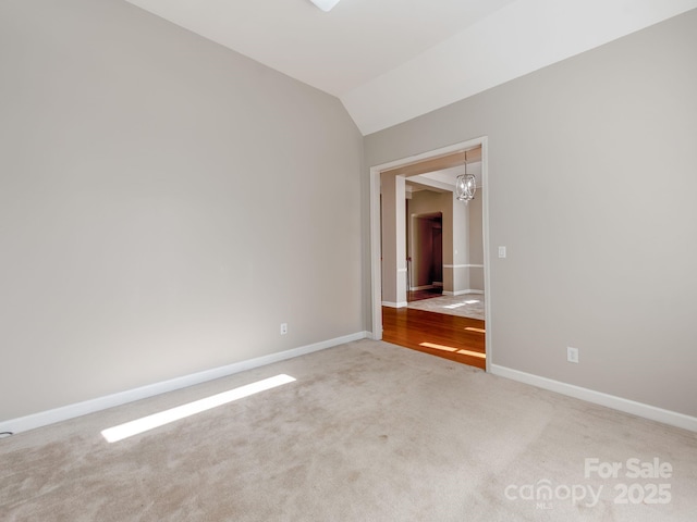 spare room featuring carpet and lofted ceiling