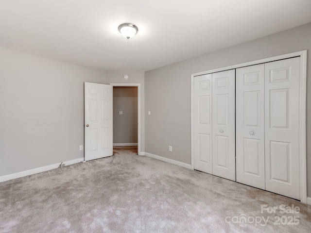 unfurnished bedroom featuring light colored carpet and a closet