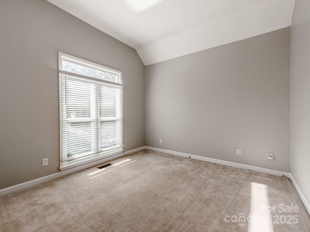 unfurnished room with light carpet and lofted ceiling