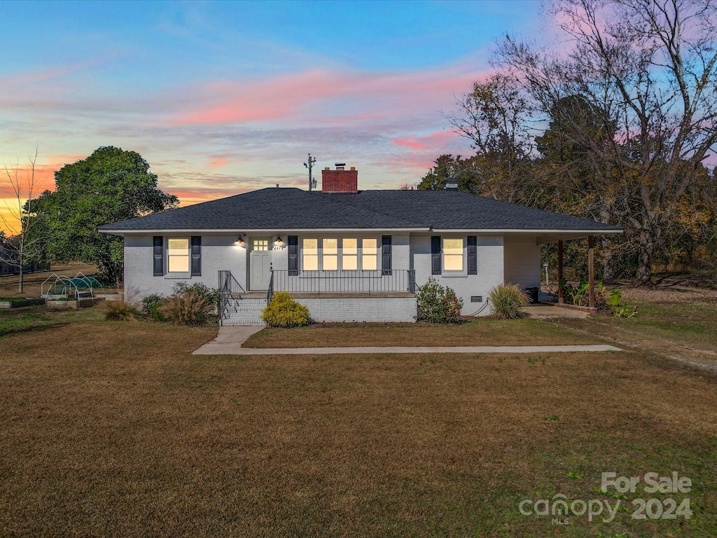 single story home featuring a lawn and a porch