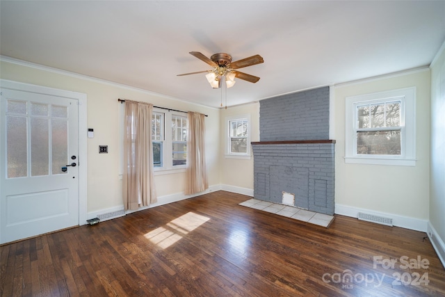 unfurnished living room with dark hardwood / wood-style flooring, ceiling fan, plenty of natural light, and a brick fireplace