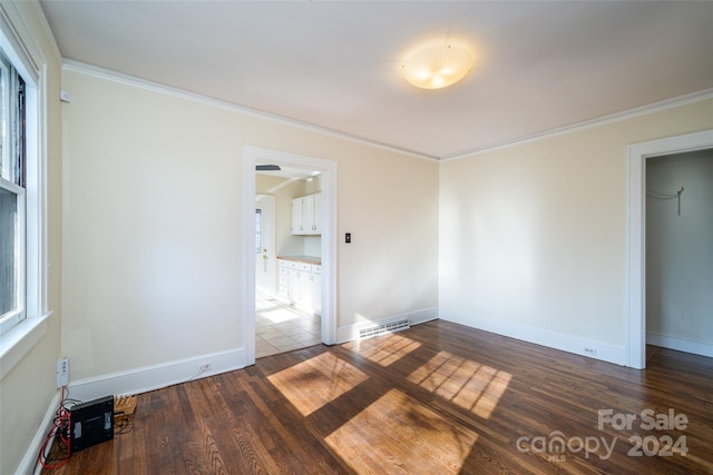 empty room with crown molding and dark hardwood / wood-style flooring