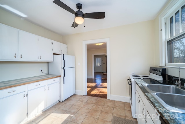 kitchen with sink, light hardwood / wood-style flooring, white fridge, stainless steel range with electric stovetop, and white cabinets