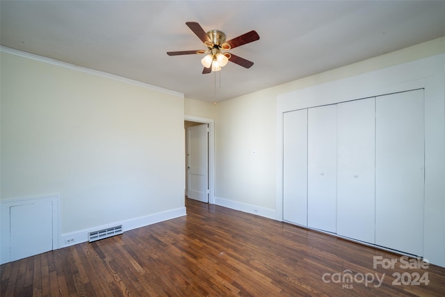 unfurnished bedroom featuring a closet, ceiling fan, crown molding, and dark wood-type flooring