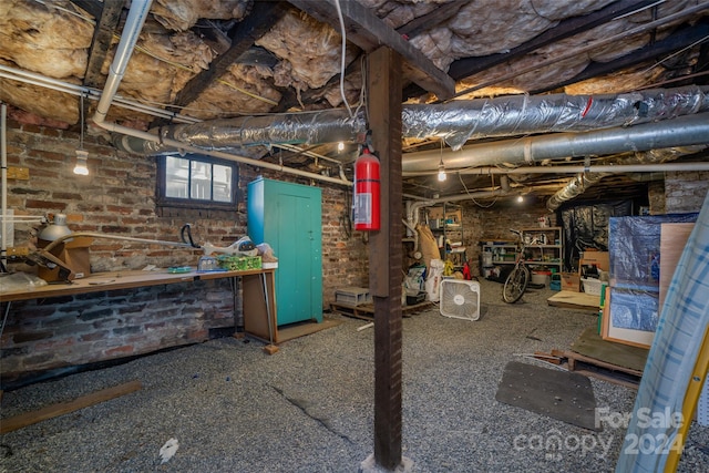 basement featuring brick wall