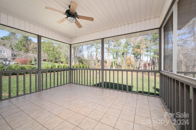 unfurnished sunroom with ceiling fan, plenty of natural light, and wood ceiling