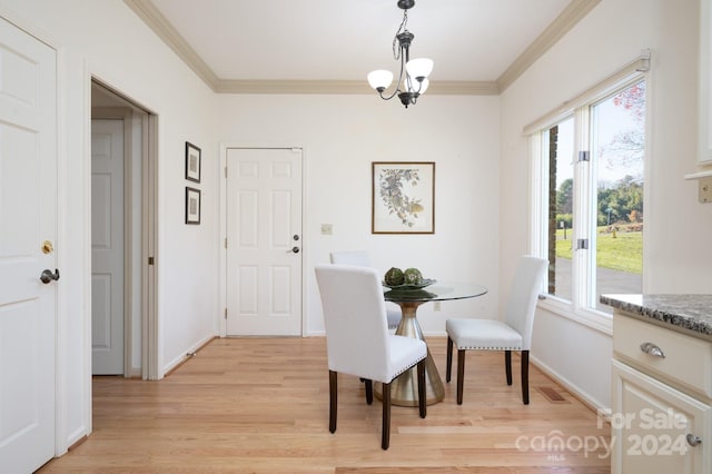 dining area featuring light hardwood / wood-style floors, ornamental molding, and a notable chandelier