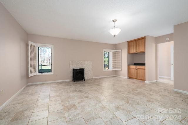 unfurnished living room with a wood stove