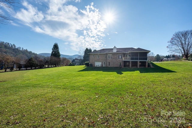 view of yard featuring a sunroom, a mountain view, and a garage