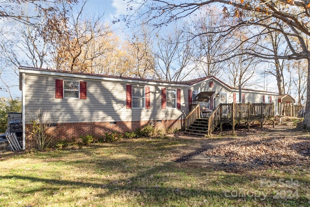 view of front of home with a wooden deck and a front lawn