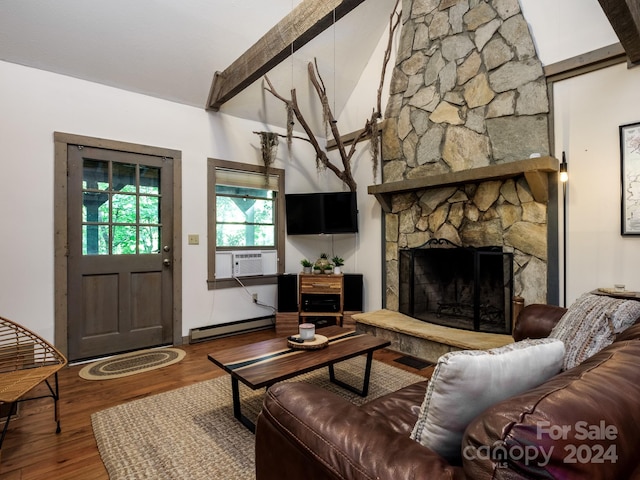 living room featuring cooling unit, hardwood / wood-style flooring, a baseboard radiator, beamed ceiling, and a stone fireplace