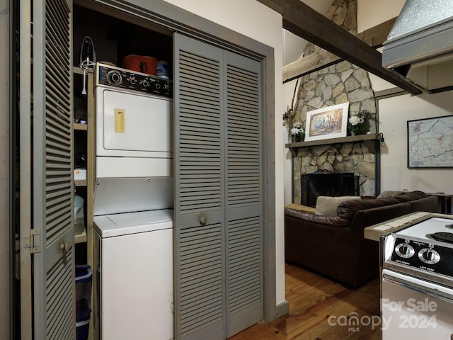 kitchen with white range with electric stovetop, a fireplace, dark hardwood / wood-style floors, and stacked washer / drying machine