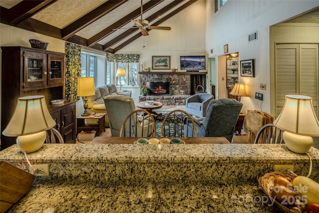 300 Glenwood Ln Unit K-38, Sugar Mountain, NC 28604 - living area featuring a ceiling fan, high vaulted ceiling, beam ceiling, a stone fireplace, and plenty of natural light