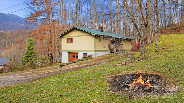 view of front of house with a mountain view and a fire pit