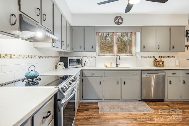 kitchen with gray cabinets, sink, dark hardwood / wood-style floors, and appliances with stainless steel finishes