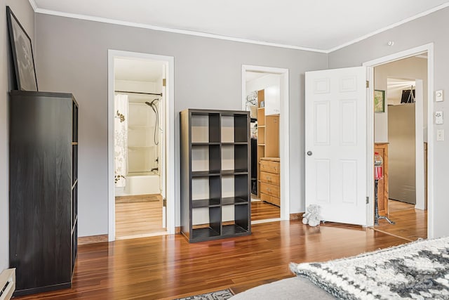 bedroom with dark hardwood / wood-style floors, ensuite bath, a baseboard radiator, and crown molding