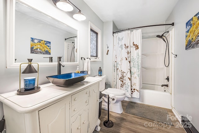 full bathroom with hardwood / wood-style floors, vanity, toilet, and shower / bath combo with shower curtain