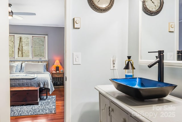 bathroom with hardwood / wood-style flooring, ceiling fan, and vanity