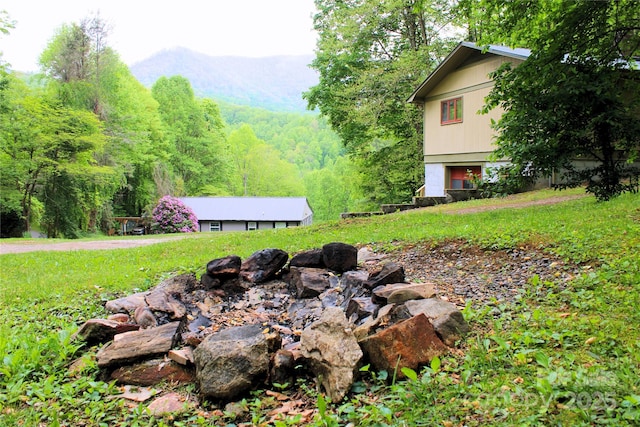 view of yard featuring a forest view and a mountain view