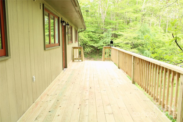 wooden deck with a wooded view