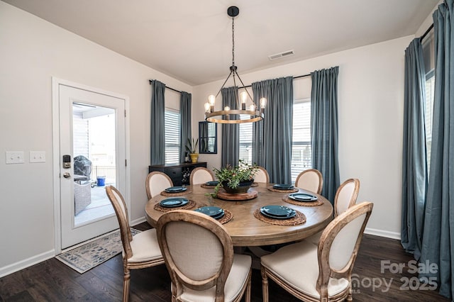 dining room featuring plenty of natural light, visible vents, a chandelier, and dark wood-style flooring