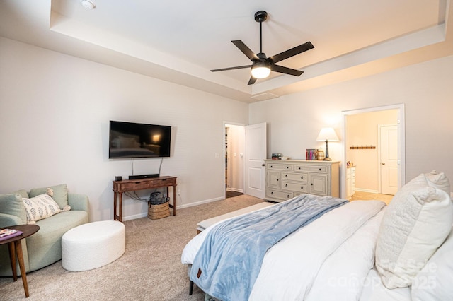 bedroom with light carpet, a raised ceiling, a ceiling fan, and baseboards