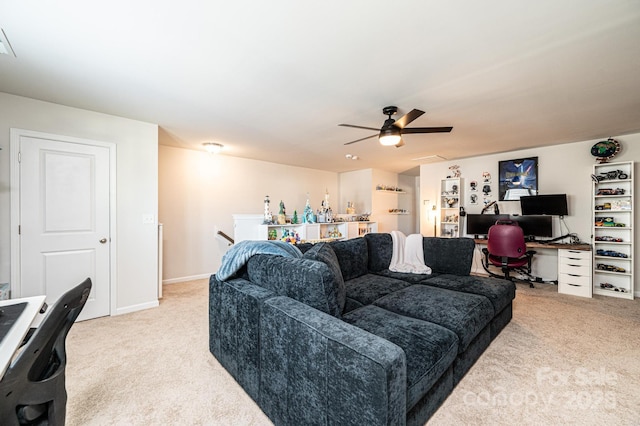 living area with baseboards, a ceiling fan, and light colored carpet