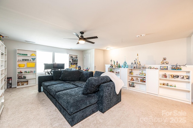 living area featuring light colored carpet and ceiling fan