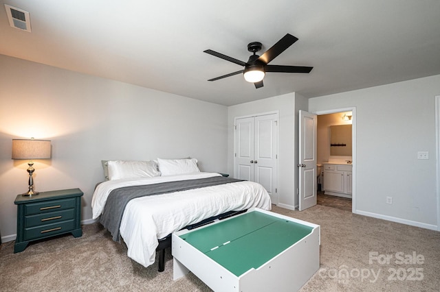 bedroom featuring light carpet, baseboards, visible vents, ensuite bath, and a closet