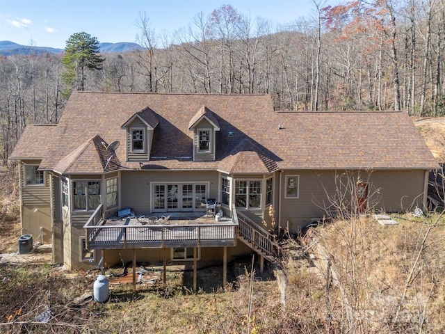 back of property featuring a deck with mountain view and central AC