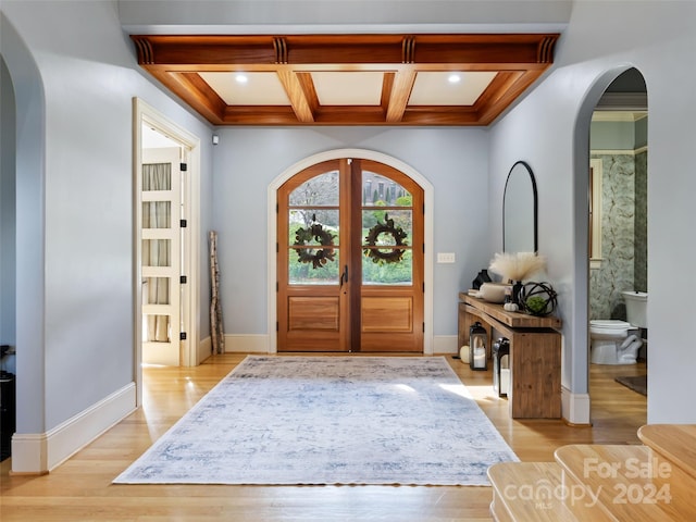 entryway with french doors, light hardwood / wood-style flooring, coffered ceiling, and beam ceiling