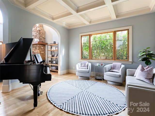 living area with beam ceiling, crown molding, coffered ceiling, and light wood-type flooring