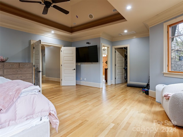 bedroom featuring ceiling fan, crown molding, a spacious closet, light hardwood / wood-style flooring, and connected bathroom