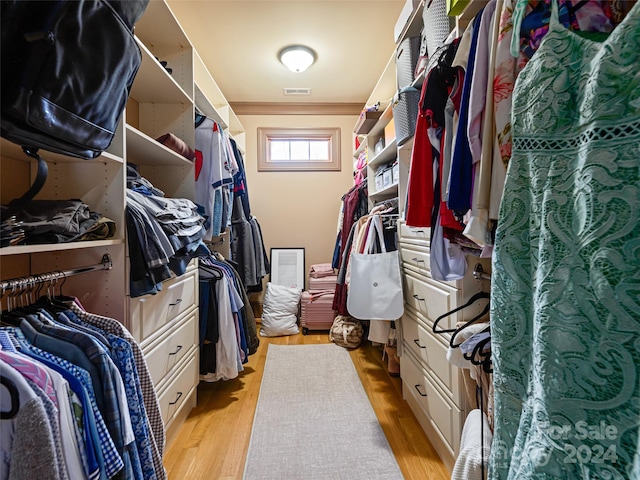 walk in closet with light hardwood / wood-style flooring