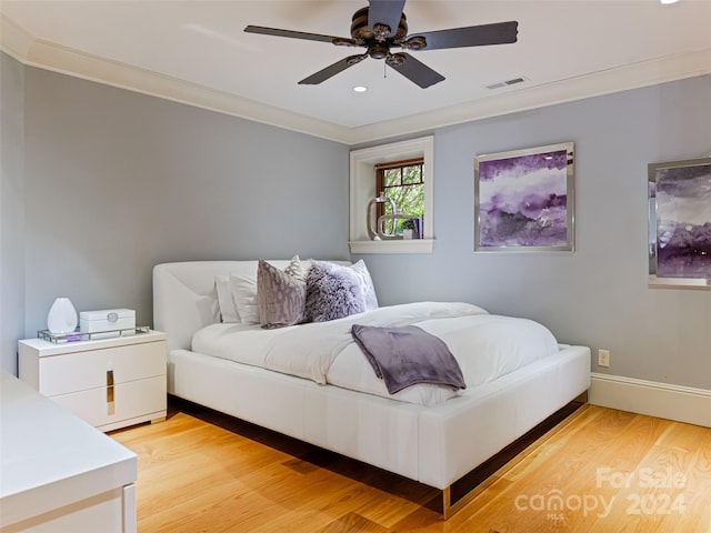 bedroom with light hardwood / wood-style floors, ceiling fan, and ornamental molding